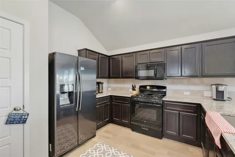 a kitchen with stainless steel appliances granite countertop a refrigerator stove and sink