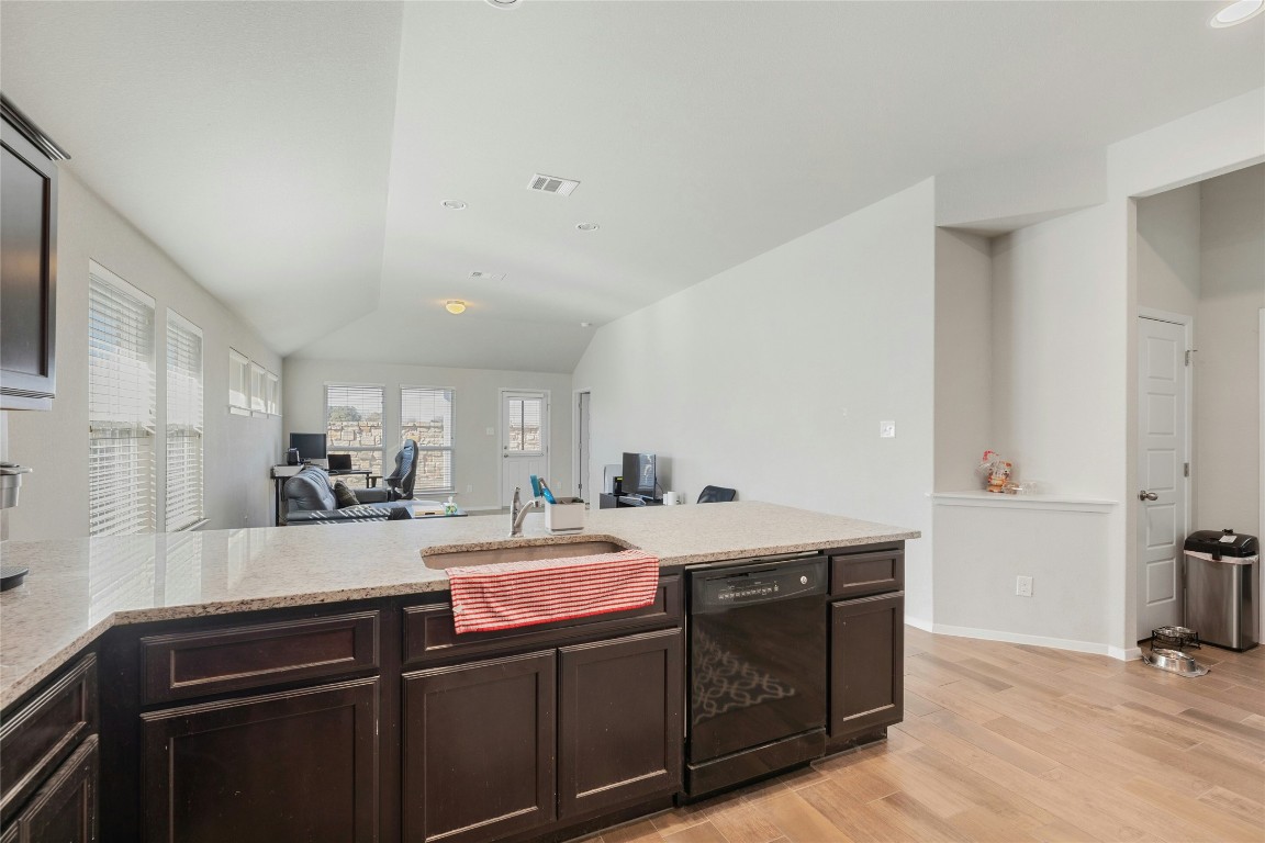 7920 Castelardo Place, Unit 50 Round Rock, TX 78665 - Photo 13 of 28 a kitchen with a sink a stove cabinets and wooden floor