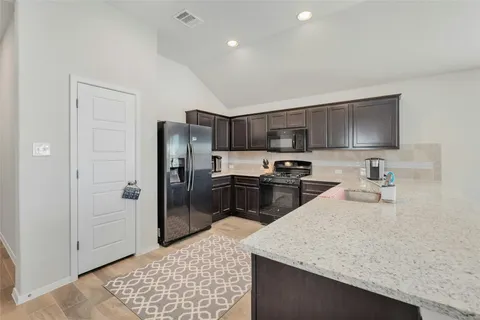 a kitchen with stainless steel appliances granite countertop a sink refrigerator and microwave