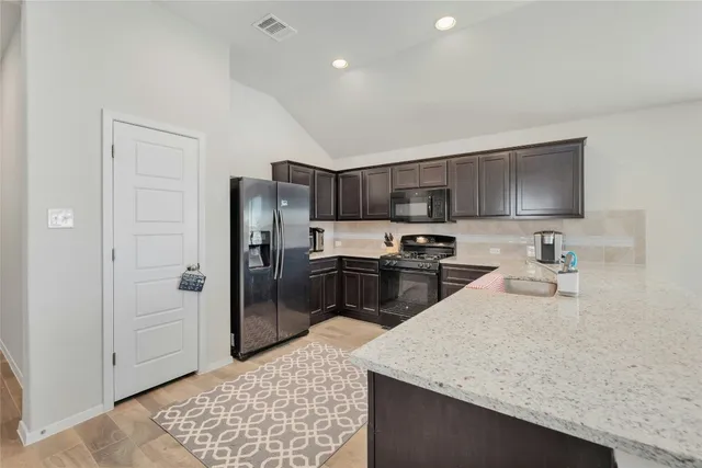 a kitchen with stainless steel appliances granite countertop a sink refrigerator and microwave