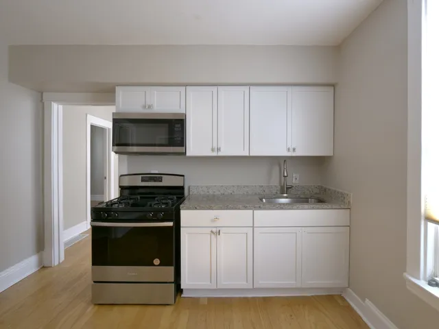 a kitchen with appliances a sink and cabinets