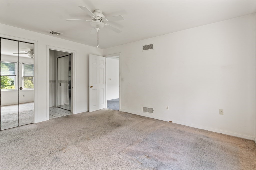 29 Ledgebrook Drive, Unit 29 Blackstone, MA 01504 - Photo 18 of 38 an empty room with a ceiling fan and glass door