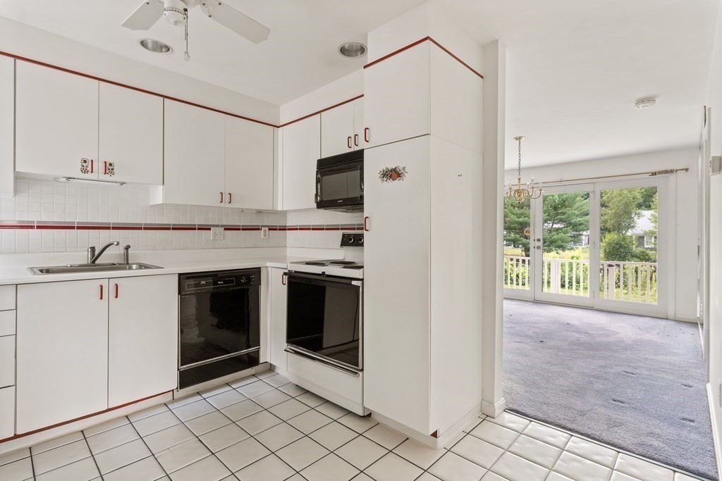 29 Ledgebrook Drive, Unit 29 Blackstone, MA 01504 - Photo 27 of 38 a kitchen with granite countertop a stove sink and cabinets