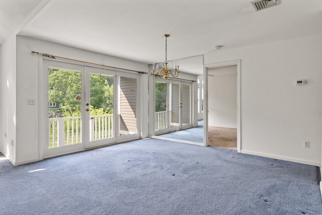 29 Ledgebrook Drive, Unit 29 Blackstone, MA 01504 - Photo 10 of 38 a view of a room with sliding glass door and chandelier
