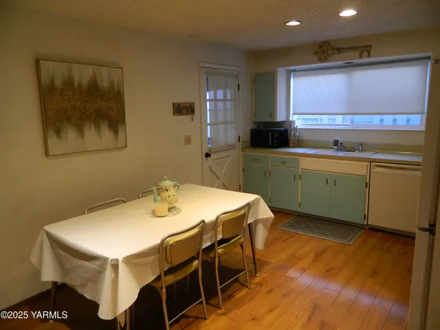a kitchen with a stove a sink cabinets and wooden floor