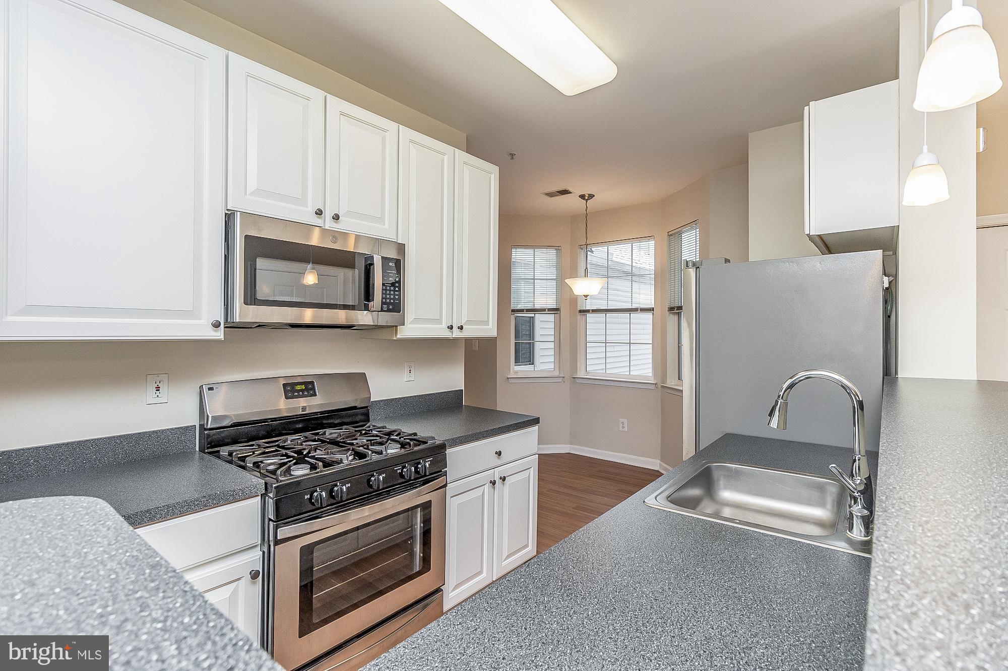18 Hawk Rise Lane, Unit 205 Owings Mills, MD 21117 - Photo 12 of 29 a kitchen with stainless steel appliances a stove a microwave and a refrigerator