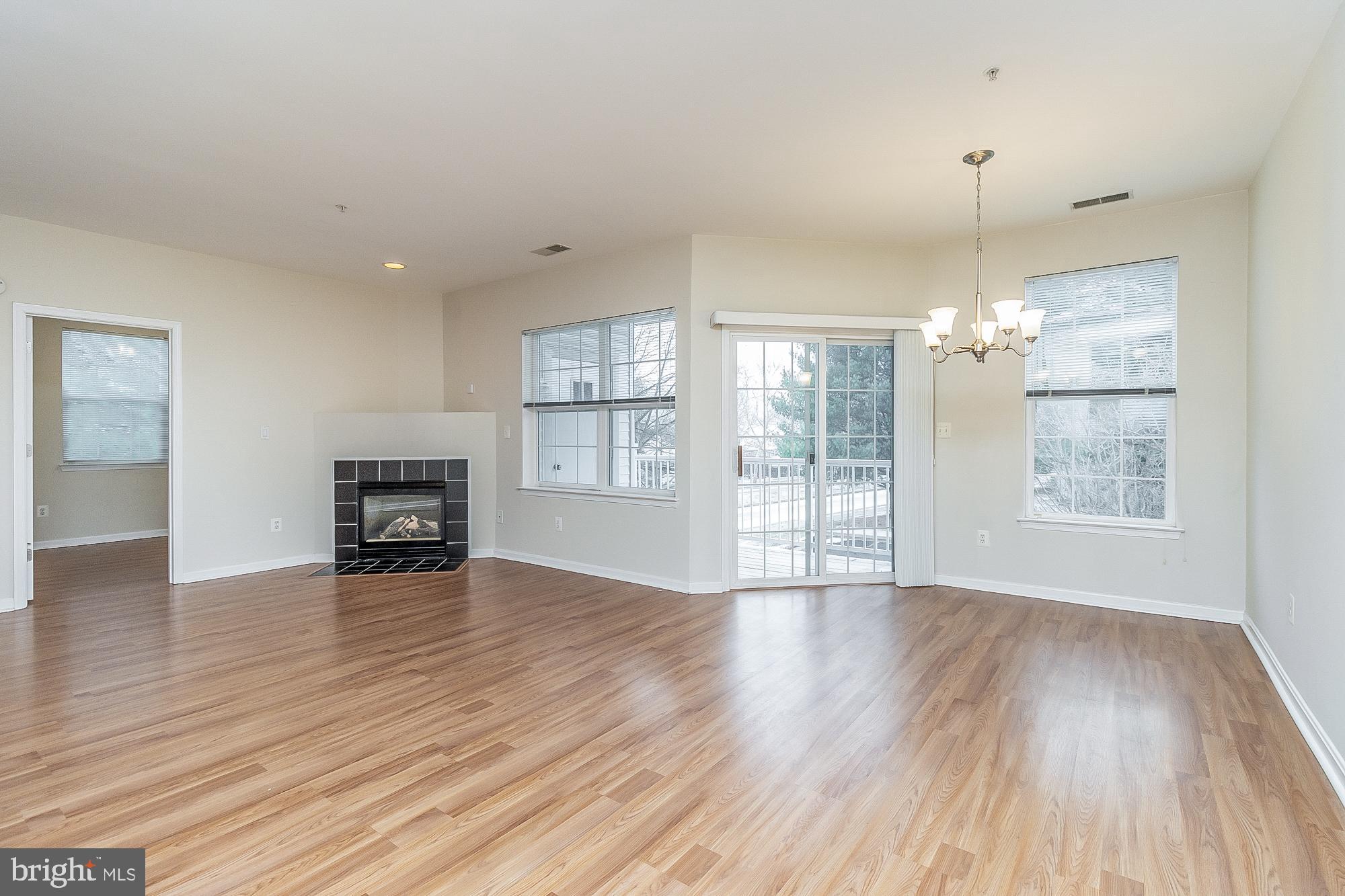 18 Hawk Rise Lane, Unit 205 Owings Mills, MD 21117 - Photo 17 of 29 a view of an empty room with a window and wooden floor