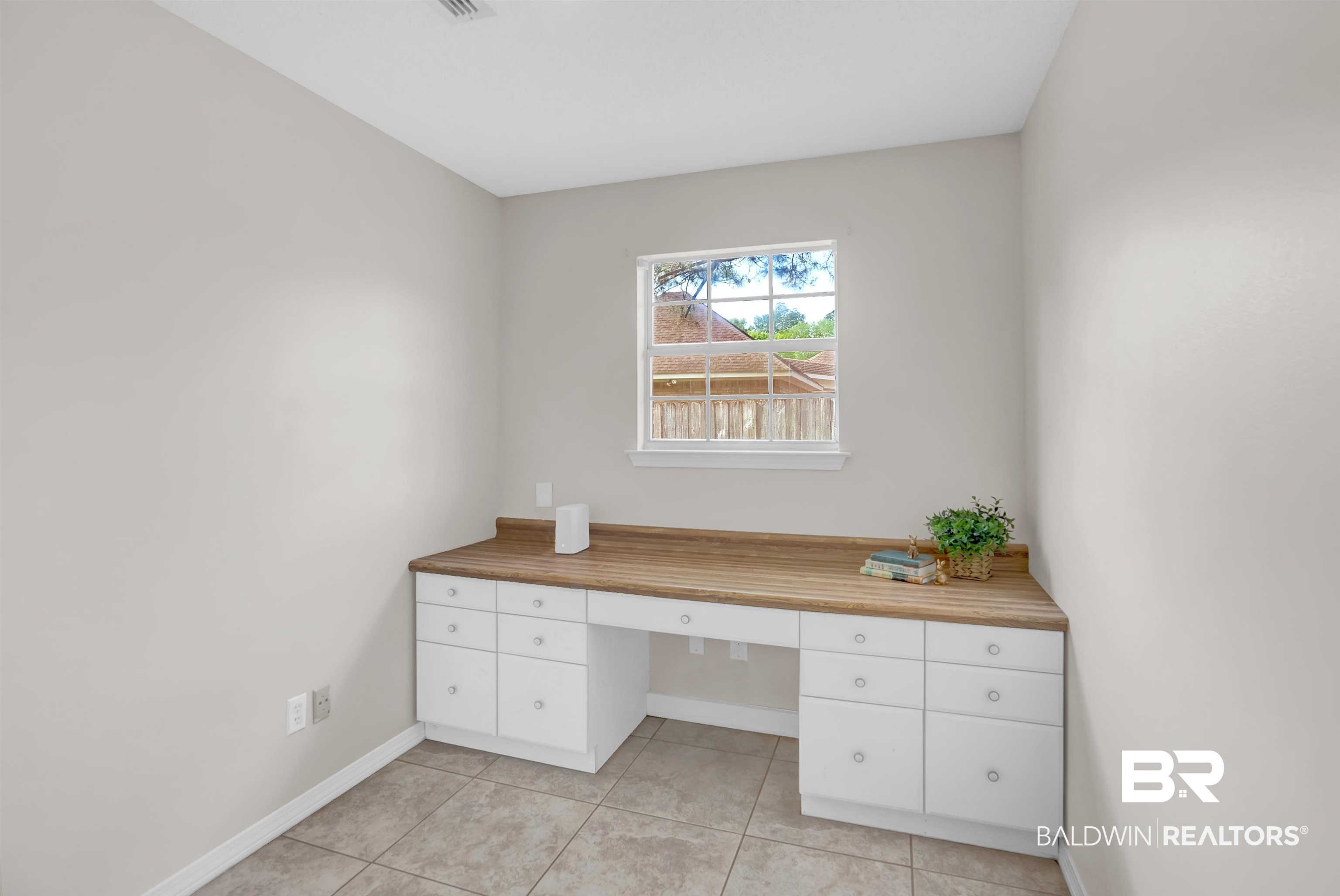 19741 Hunters Loop Fairhope, AL 36532 - Photo 28 of 42 Unfurnished office featuring light tile patterned floors, built in desk, and baseboards