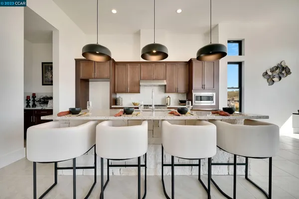 a kitchen with stainless steel appliances a dining table chairs and white cabinets