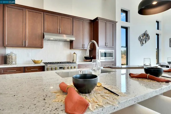 a kitchen with stainless steel appliances granite countertop a sink and a stove