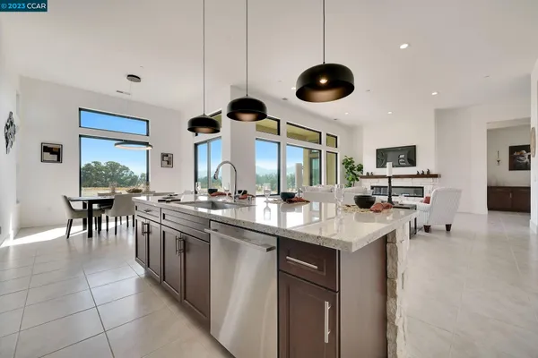 a kitchen with stainless steel appliances a stove a sink and chairs