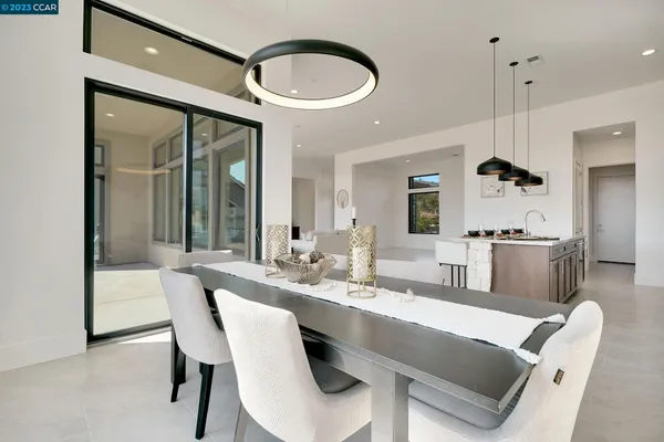 a living room with furniture a flat screen tv and kitchen view