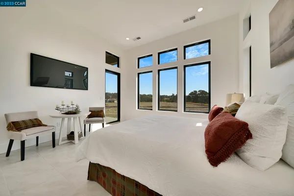 a spacious bedroom with a bed a mirror and desk