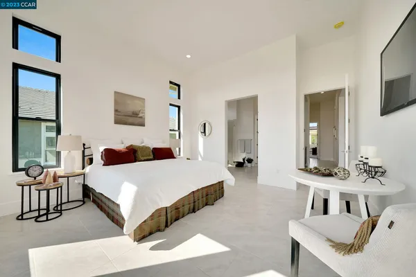 a bedroom with bed and a flat tv screen on dresser
