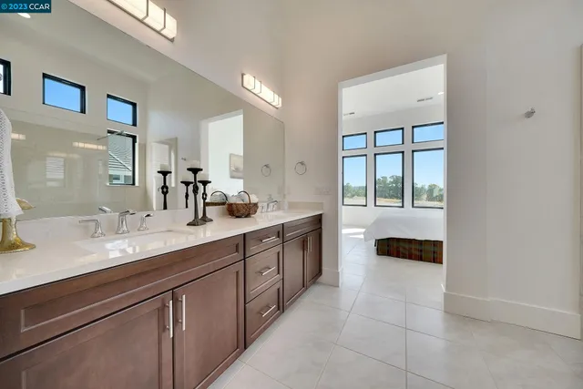a bathroom with double vanity sinks a large mirror and a shower