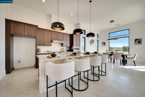 a kitchen with a dining table chairs sink and cabinets