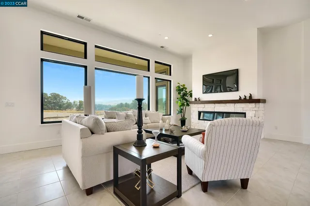 a living room with furniture a flat screen tv and a floor to ceiling window