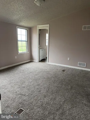 an empty room with windows and cabinet