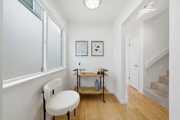 a kitchen with stainless steel appliances granite countertop a sink dishwasher a stove a refrigerator with a dining table and chairs with wooden floor