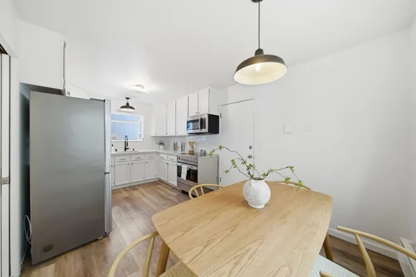 a kitchen with a sink dishwasher a white refrigerator and cabinets