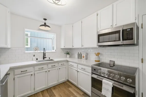 a kitchen with stainless steel appliances a stove microwave and refrigerator
