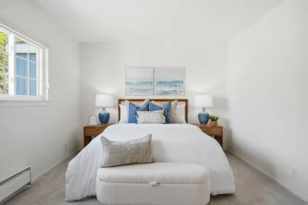 a spacious bedroom with a bed and a lamp