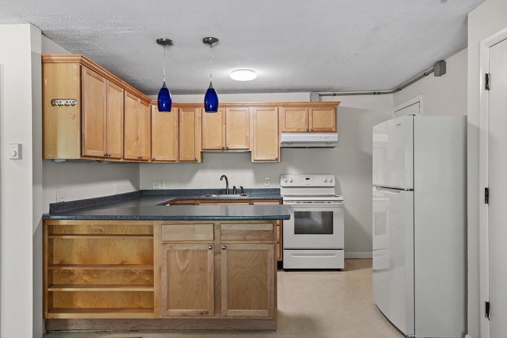 5 Turnpike Road, Unit 229 Townsend, MA 01469 - Photo 7 of 20 a kitchen with stainless steel appliances granite countertop a stove and a refrigerator