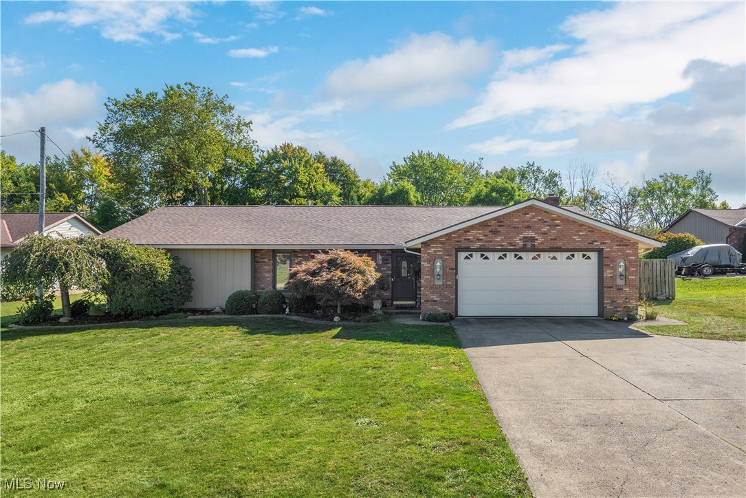 Single story home with a garage and a front yard