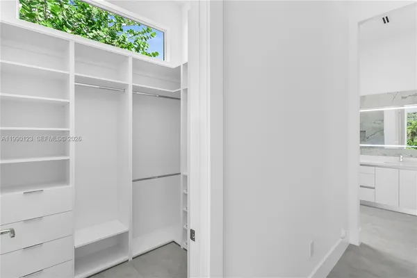 a view of walk in closet with empty racks