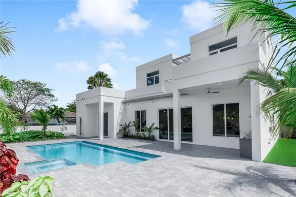 a view of a house with swimming pool and next to a yard