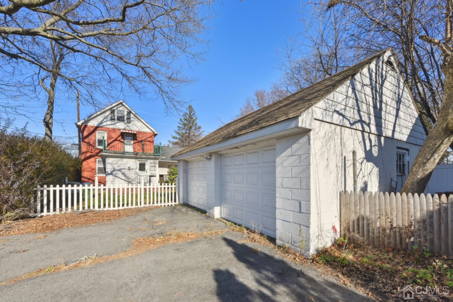 711 Old Post Road Edison, NJ 08817 - Photo 3 of 27 a view of a brick house with a small yard and wooden fence and bench