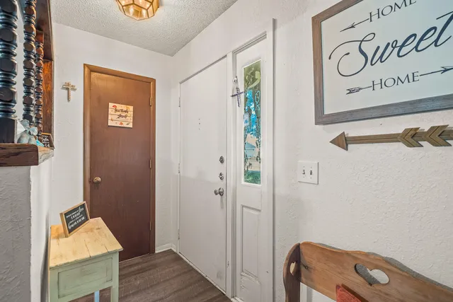 a view of a hallway with wooden floor and a bathroom