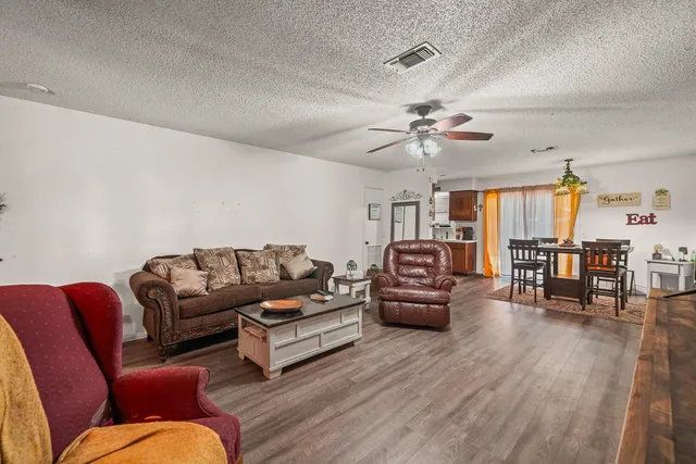 a living room with furniture ceiling fan and a rug