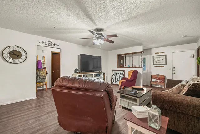 a living room with furniture a flat screen tv and a clock