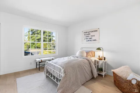 a bedroom with a bed and painting on the wall