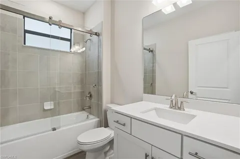 a bathroom with a granite countertop sink a toilet and shower