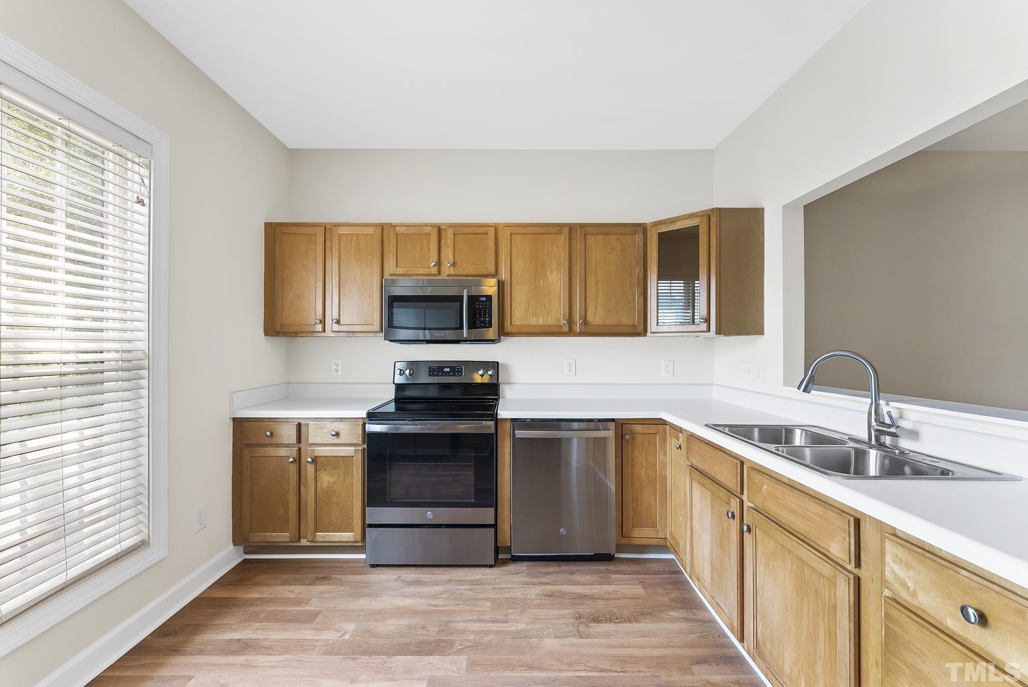 8706 Leeds Forest Lane Raleigh, NC 27615 - Photo 12 of 22 a kitchen with stainless steel appliances granite countertop a sink stove and microwave
