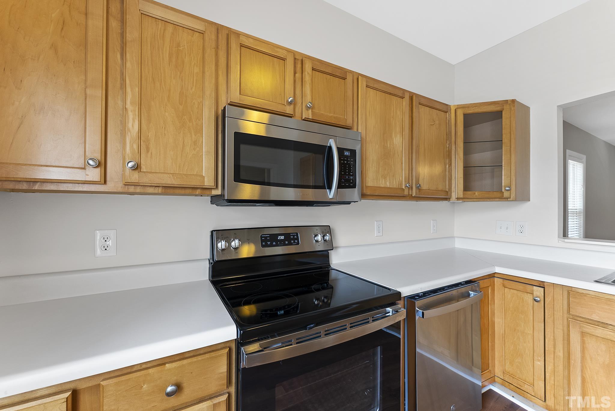 8706 Leeds Forest Lane Raleigh, NC 27615 - Photo 15 of 22 a kitchen with stainless steel appliances a stove a sink and a microwave