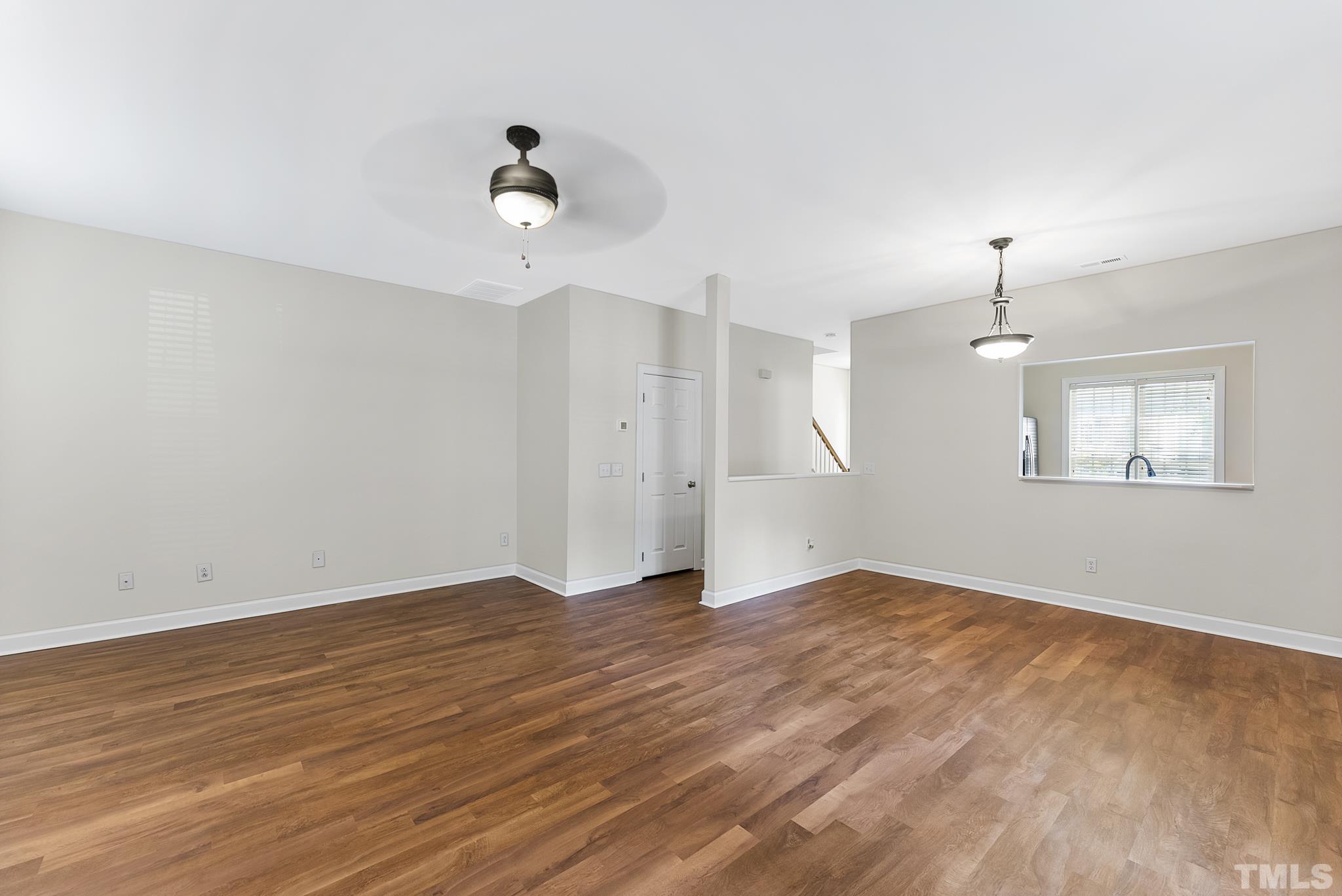 8706 Leeds Forest Lane Raleigh, NC 27615 - Photo 19 of 22 an empty room with wooden floor ceiling fan and windows