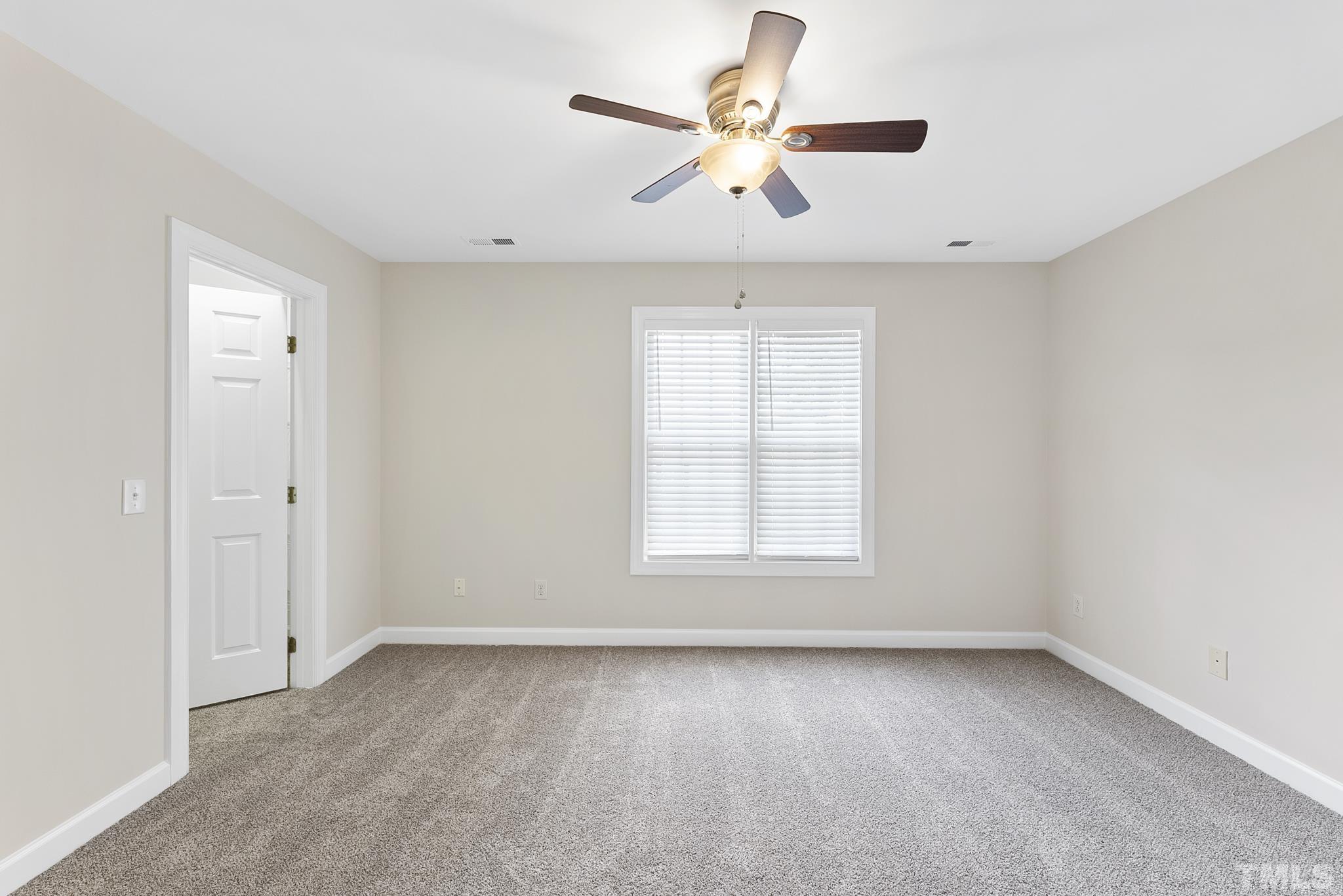 8706 Leeds Forest Lane Raleigh, NC 27615 - Photo 3 of 22 an empty room with a window and a fan