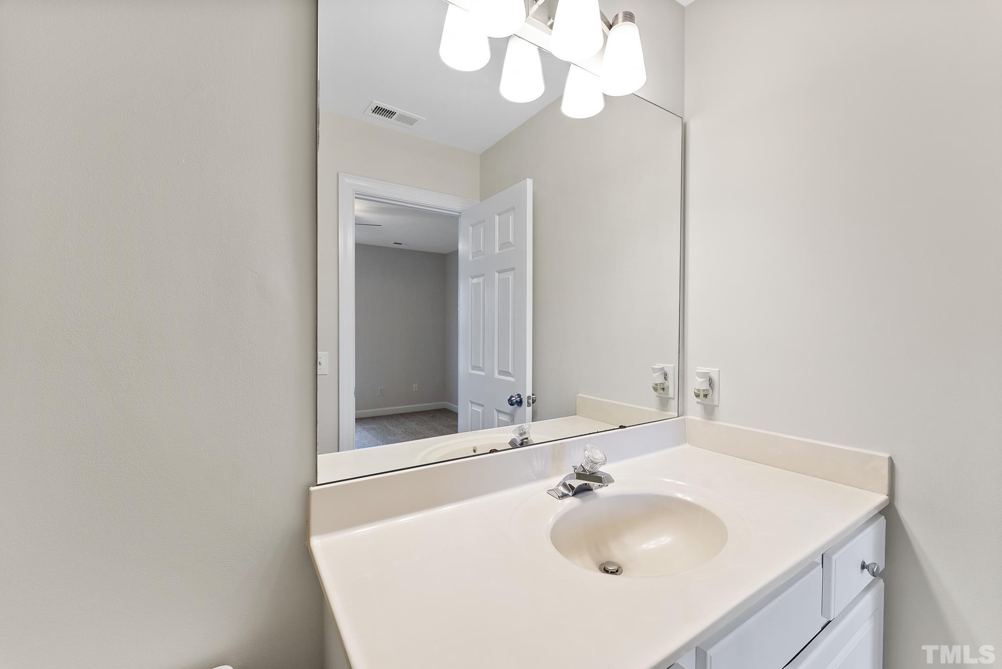 8706 Leeds Forest Lane Raleigh, NC 27615 - Photo 4 of 22 a bathroom with a sink and a mirror