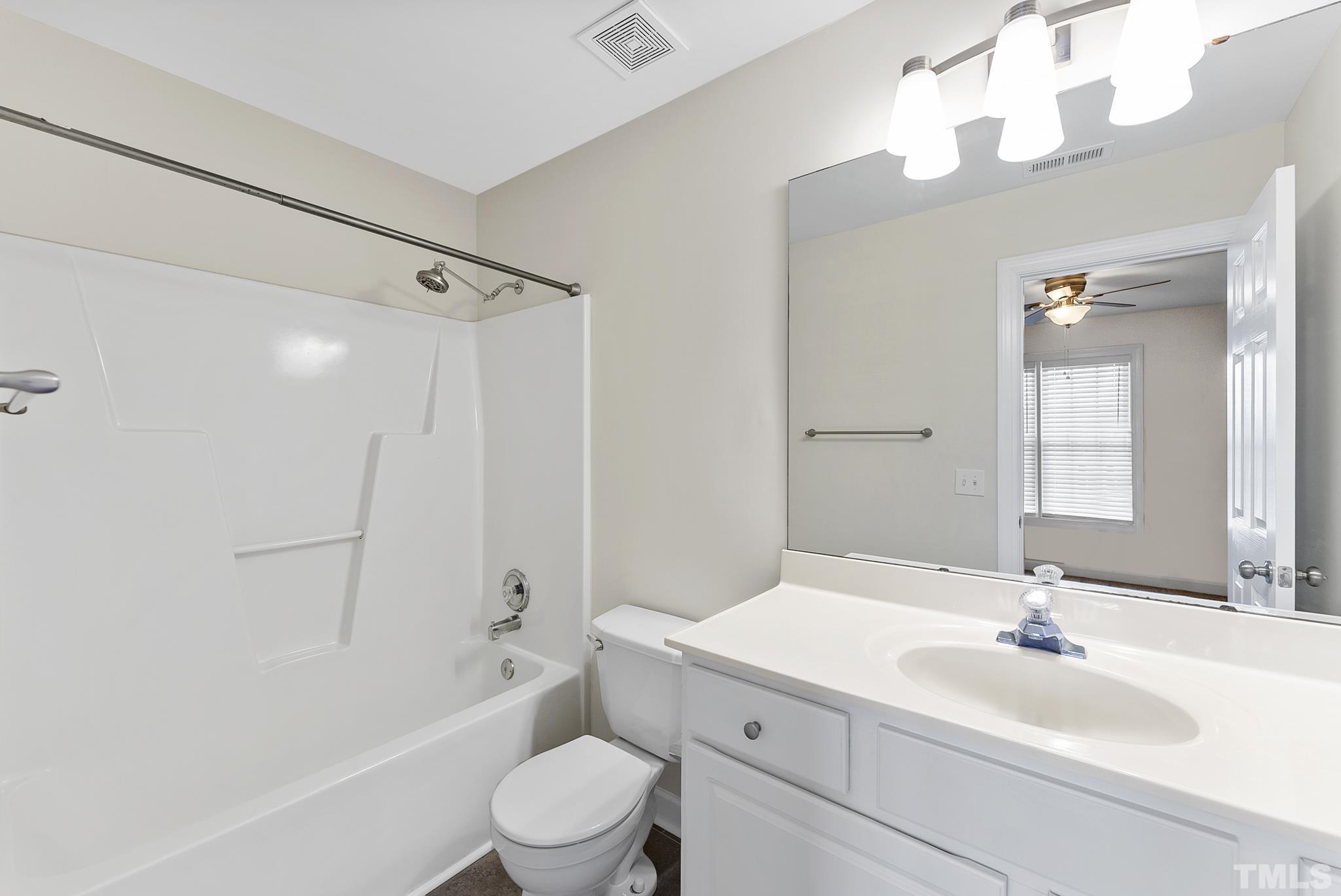 8706 Leeds Forest Lane Raleigh, NC 27615 - Photo 5 of 22 a bathroom with a sink a toilet a mirror and shower