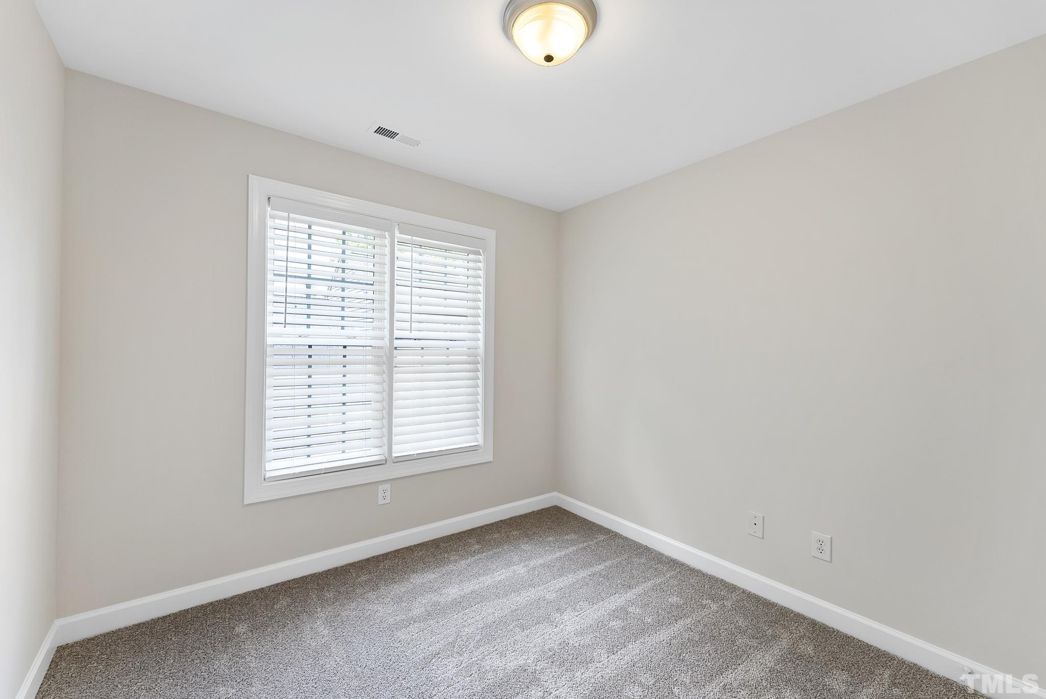 8706 Leeds Forest Lane Raleigh, NC 27615 - Photo 6 of 22 a view of an empty room with wooden floor and a window