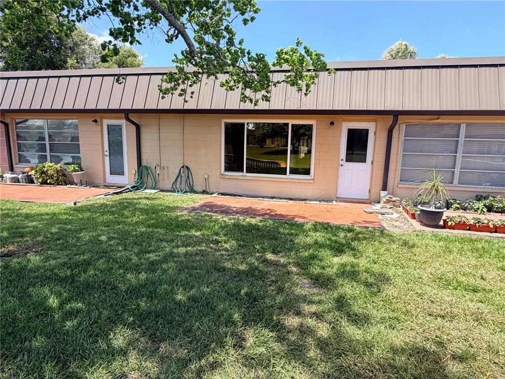 4446 Rustic Drive, Unit E New Port Richey, FL 34652 - Photo 1 of 12 a front view of a house with a garden and yard