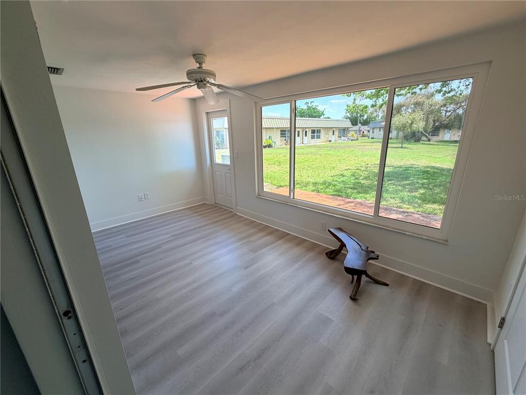 4446 Rustic Drive, Unit E New Port Richey, FL 34652 - Photo 8 of 12 wooden floor in an empty room with a window