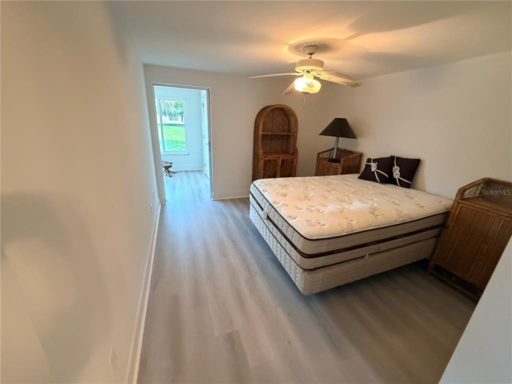 4446 Rustic Drive, Unit E New Port Richey, FL 34652 - Photo 9 of 12 a bed room with a bed and a chandelier