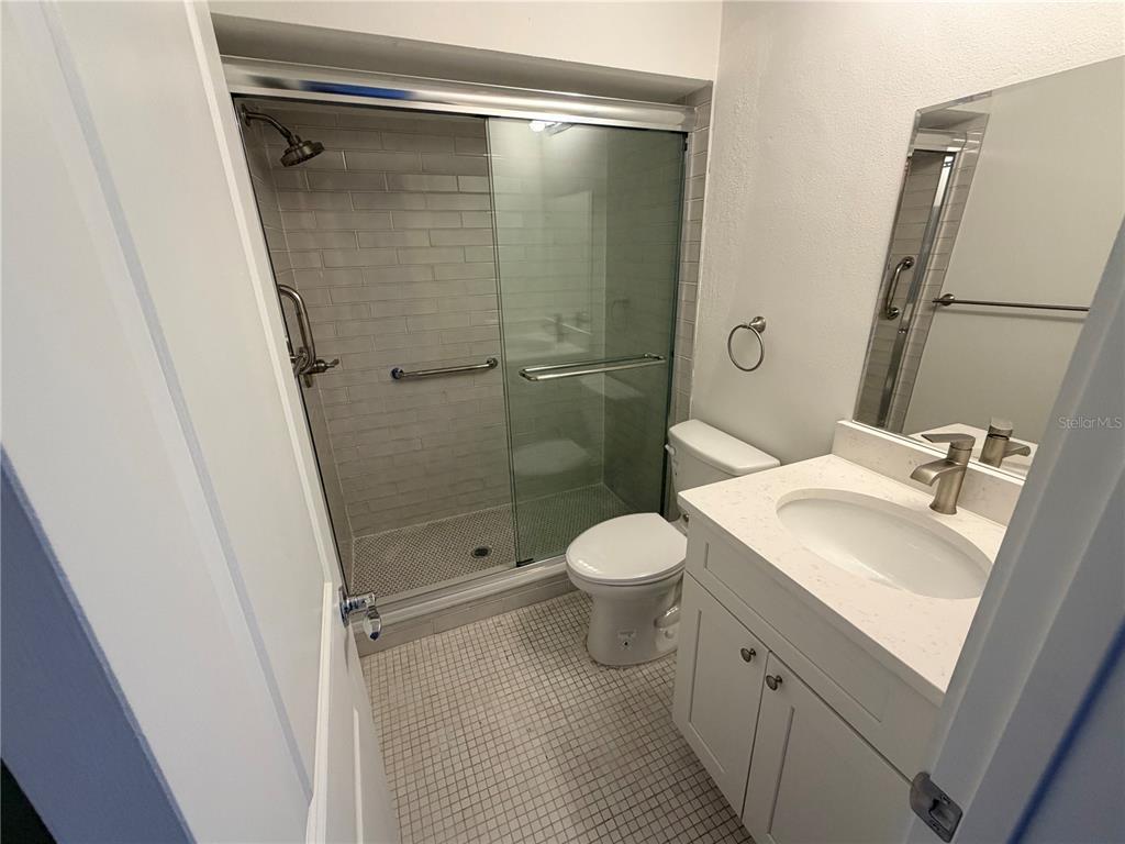4446 Rustic Drive, Unit E New Port Richey, FL 34652 - Photo 10 of 12 a bathroom with a sink a toilet and shower