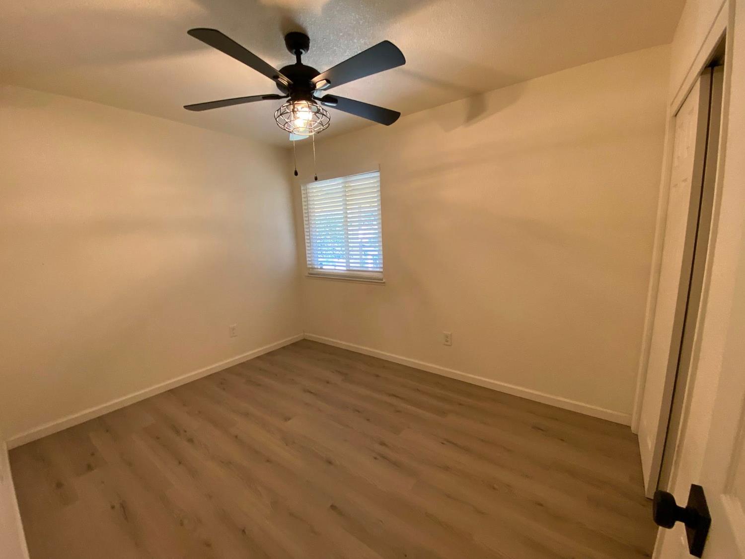 1201 Chateaugay Drive Modesto, CA 95356 - Photo 11 of 32 an empty room with a window and a fan