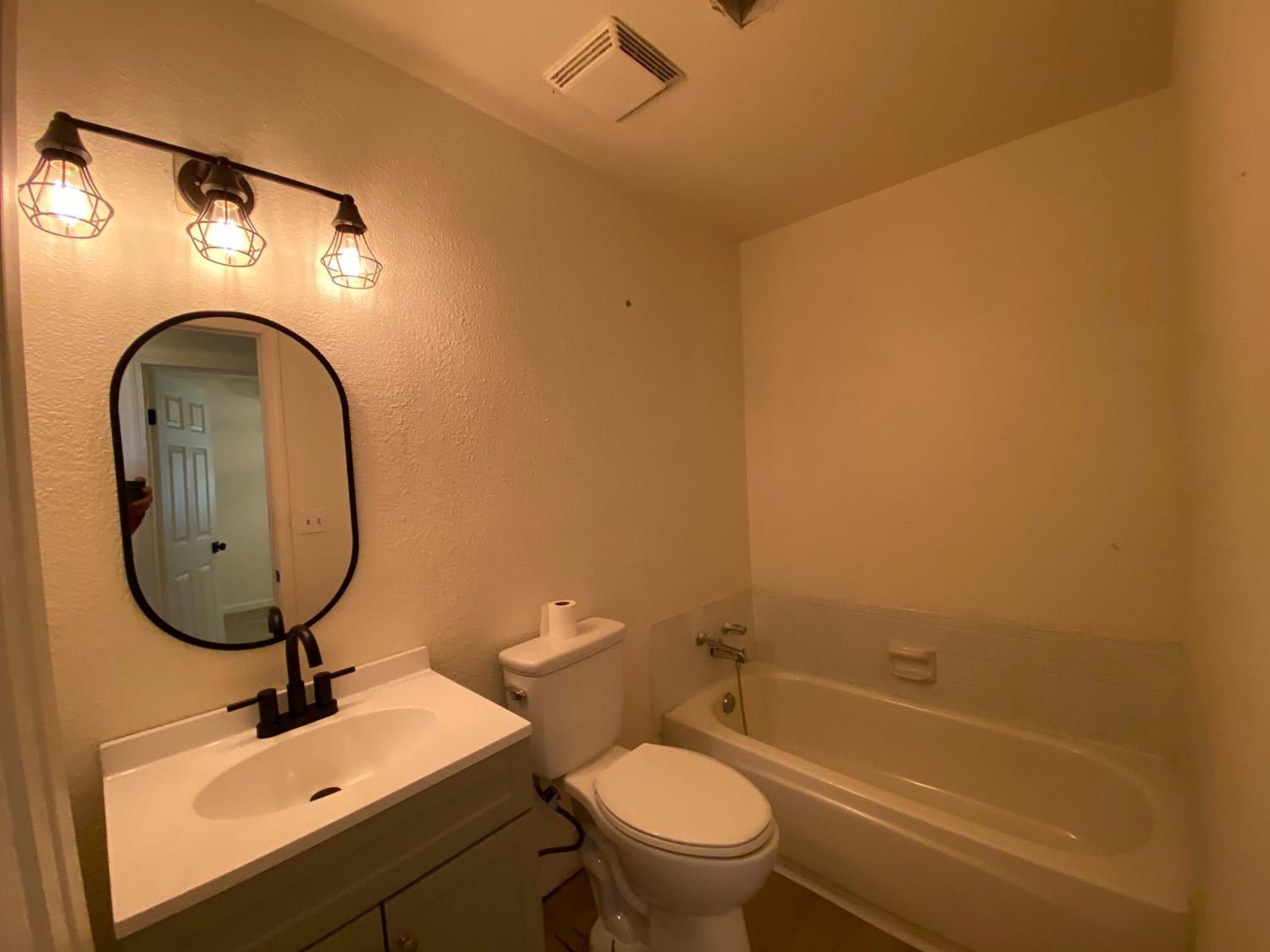 1201 Chateaugay Drive Modesto, CA 95356 - Photo 12 of 32 a bathroom with a sink a toilet and a mirror