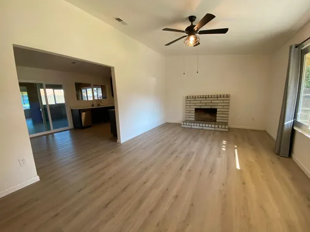 a view of main area fire place window and wooden floor